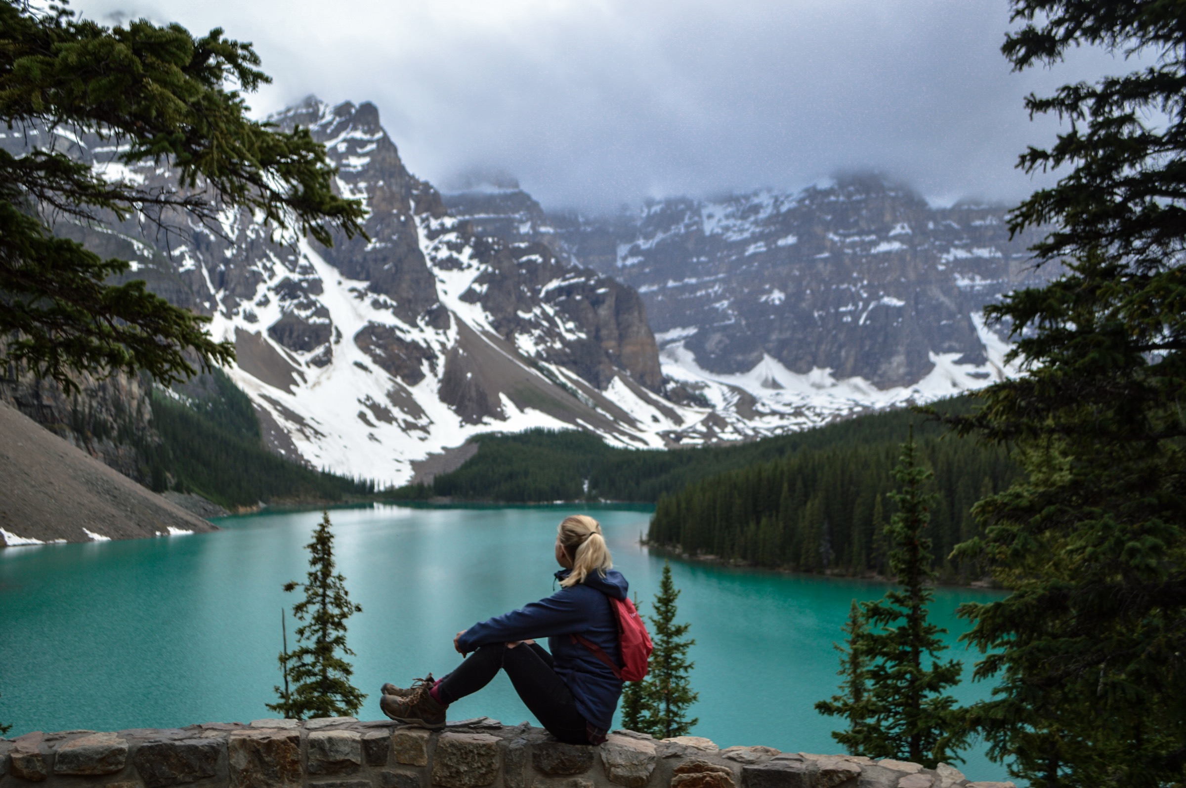 Woman sitting by a river in the mountains